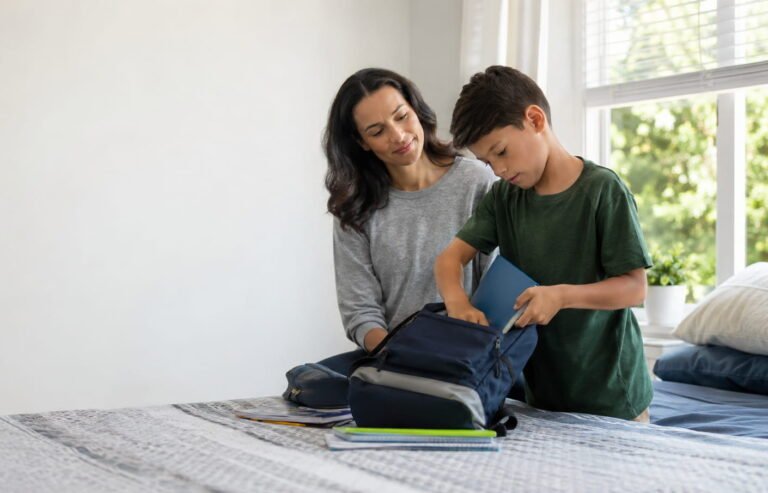 Padre acompañando a su hijo de unos 9 años mientras prepara su propia mochila escolar